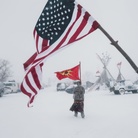 Contemporary Issues - First Prize, Stories © Amber Bracken, Standing Rock, Alcune persone portano la bandiera americana e quella della Mohawk Warrior Society al campo di protesta contro il Dakota Access Pipeline, in Cannon Ball, North Dakota, USA