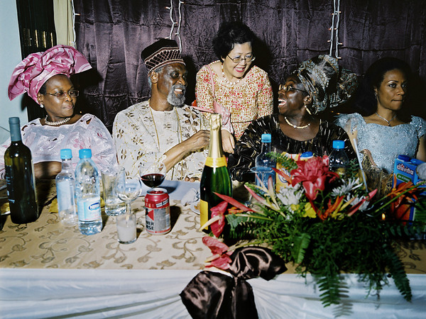 Paolo Woods, Mrs. Wood in her immense restaurant, the 5 floors, 1500 seats Golden Gates of Lagos. The new president of the Nigerian senate, Antony Mogbongubola Soetan (on the left of the Champagne bottle) has come here to celebrate his 70th birthday in the company of about 200 guests, all members of the Nigerian elite | © Paolo Woods/Anzenberger