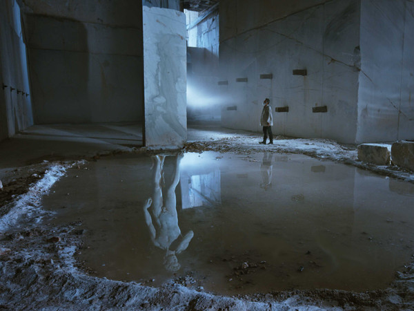 Enrico Lo Verso, nel ruolo di Michelangelo, rievoca il ricordo del David che si materializza come riflesso del monolite di marmo, all’interno della Cava di Marmo di Carrara, da cui ha inizio la narrazione. Scena tratta dal film Michelangelo Infinito | Courtesy of Sky