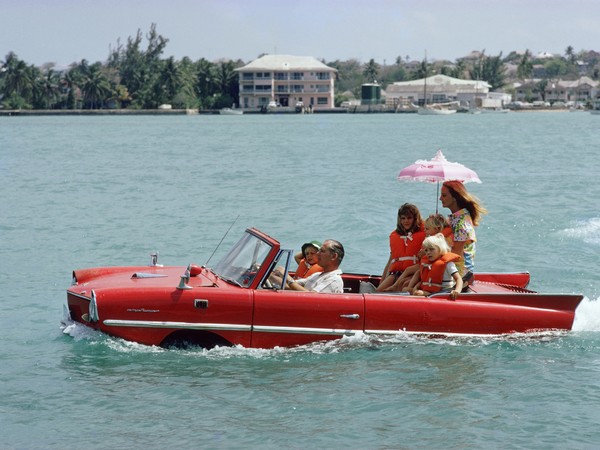 Slim Aarons, Sea Drive, Il produttore cinematografico Kevin McClory porta la moglie Bobo Sigrist e la loro famiglia a fare un giro in un "Amphicar" attraverso il porto al Nassau, 1967