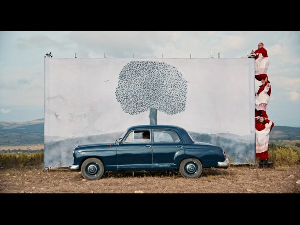 Edgar Honetschläger, fotogramma dal film 2: Il momento in cui i sogni diventano realtà - i cardinali Teco Celio, Cosimo Cinieri e Antonio Salines arrotolano il dipinto in movimento e guidano Yukika Kudo (Kaya), Philippe Spall (il diavolo) Pauline Acquart (Lydia) attraverso il continente americano disegnato e dipinto