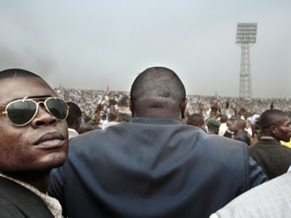 Guy Tillim, Jean-Pierre Bemba surrounded by his body guards walks into an election rally in central Kinshasa, 2006, from the series "Congo Democratic"