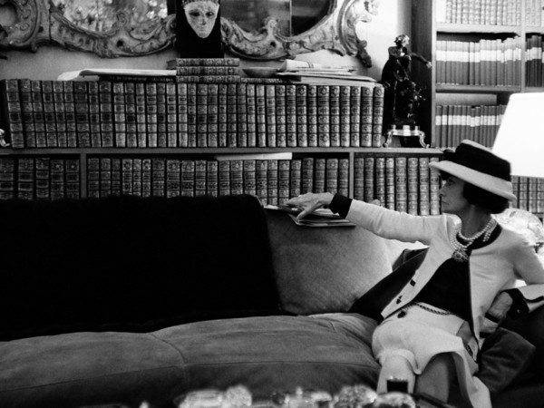 Douglas Kirkland, Ritratto di Gabrielle Chanel sul suo divano mentre guarda la sua biblioteca, Luglio 1962. Fotografia Collezione Douglas Kirkland, Los Angeles