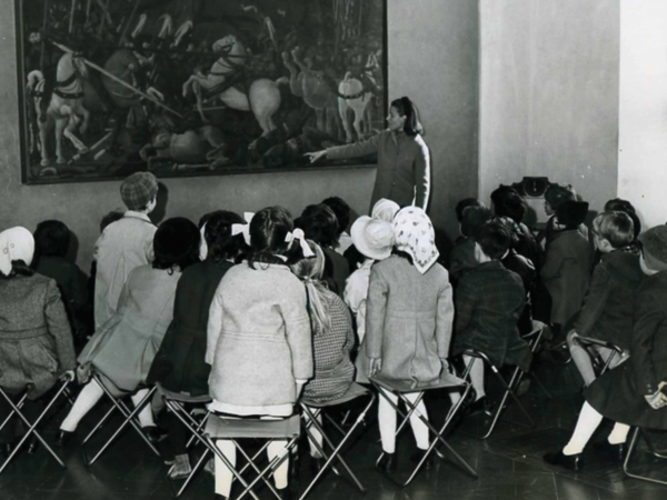 Bambini seduti di fronte alla Battaglia di San Romano del pittore Paolo Uccello