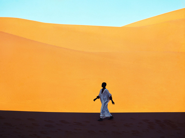 Un ragazzo attraversa una valle di dune. Kerzaz, Algeria 1972. © Kazuyoshi Nomachi