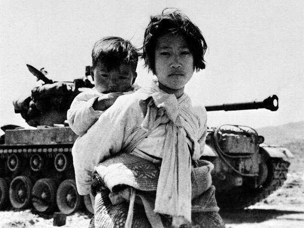 Ragazzina coreana con il fratello sulle spalle a nord di Seul durante la guerra di Corea, 1951 