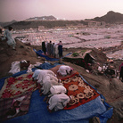 I pellegrini recitano il Maghrib dopo il tramonto nella tendopoli di Mina, allestita per accoglierli durante l’Hajj. La Mecca, Arabia Saudita 1995. © Kazuyoshi Nomachi