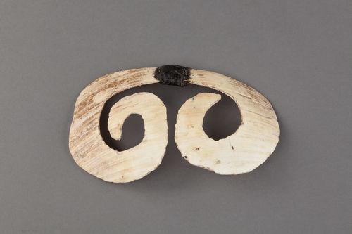 Cultura Asmat, Provincia Papua, Indonesia. Ornamento nasale (bipane ) sec. XX. Conchiglia/ intaglio, rafia, cera d'api. Museo delle Culture, Milano. Coll. Maurizio Leigheb. Inv. SEA 00174