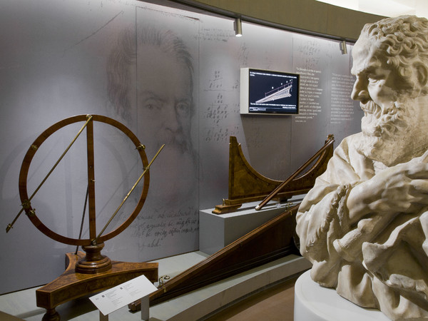 Museo Galileo: una veduta della sala dedicata allo scienziato toscano. In primo piano busto in marmo di Galileo (Carlo Marcellini, 1674 - 1677); sullo sfondo apparecchiature per esperienze sulla scienza del movimento, da sinistra a destra: apparecchio per esperienze sui moti pendolari, piano inclinato e discesa brachistocrona | © Museo Galileo, Firenze