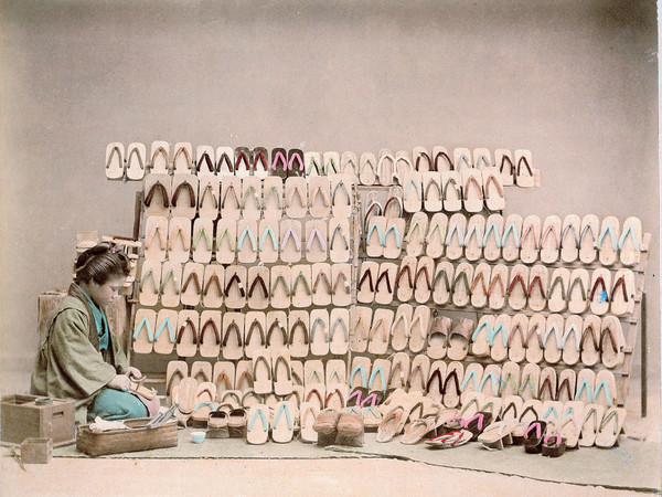 Ogawa Kazumasa (attr.), Artigiana in posa a lato di una parete di zoccoli tradizionali, 1890 circa, Giappone Segreto. Capolavori della fotografia dell'800 | Courtesy of Palazzo del Governatore, Parma 2016
