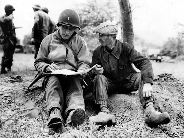 Un civile francese fornisce informazioni sui movimenti del nemico a un tenente americano. Normandia, Francia, giugno 1944