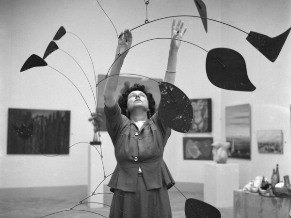 Dino Jarach (1914 - 2000), Peggy Guggenheim con Arco di petali di Alexander Calder alla Biennale di Venezia, Venezia, 1948, Stampa a posteriori, Stampa alla gelatina d’argento, Peggy Guggenheim Collection Archives, Venice | Courtesy of Solomon R. Guggenheim Foundation Photo Archivio Camera Photo Epoche Gift, Cassa di Risparmio di Venezia, 2005